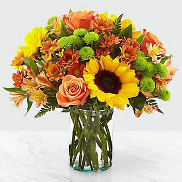 Vibrant Blooms, Stunning Floral Arrangement, Orange Roses, Sunflowers, Chrysanthemums, Alstroemeria, Green Button Chrysanthemums, Leather Fern Leaves, Glass Vase
